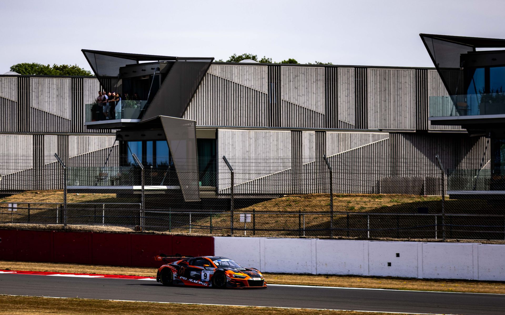 The car sweeping past the hospitality suite on a fast lap